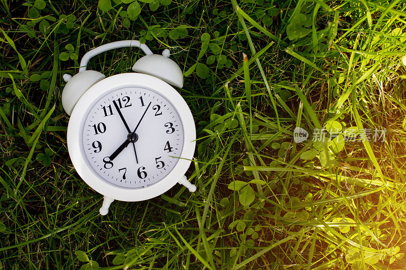 Modern white alarm clock on green background. Time is money mockup. Time-limit. Business deadline. Copy space.